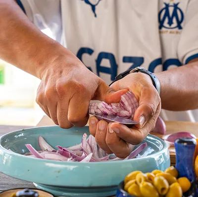 Hands preparing ingredients for a tajine during an Essaouira cooking class